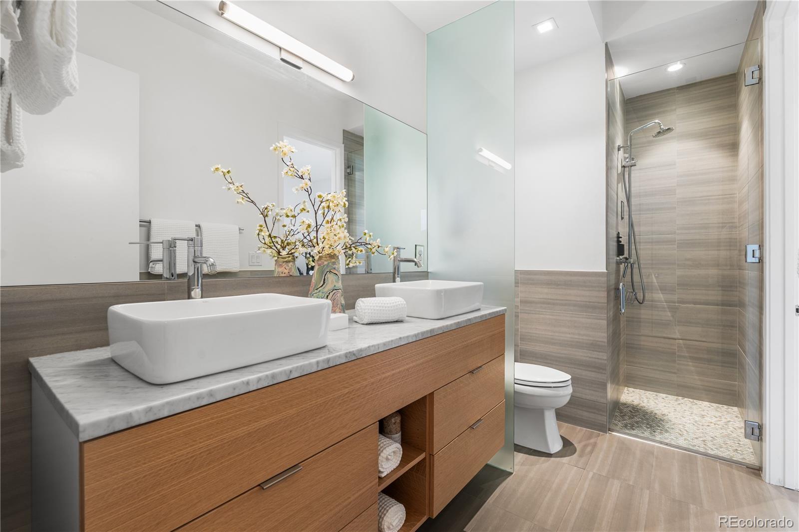 1115 West 37th Avenue Denver, CO 80211 - Photo 35 of 50 a bathroom with a granite countertop sink a toilet a mirror and shower
