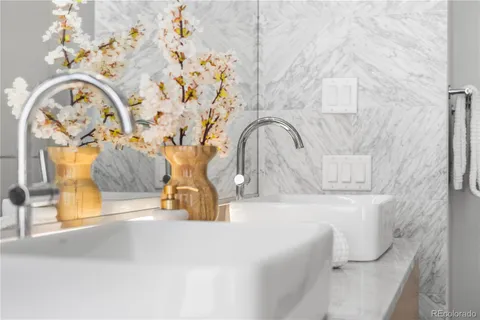 a bathroom with a granite countertop sink a mirror and shower