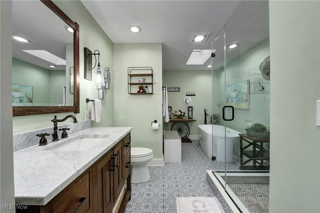 5927 Highland Road Highland Heights, OH 44143 - Photo 17 of 22 Full bathroom featuring a skylight, plus walk in shower, tile patterned flooring, and vanity