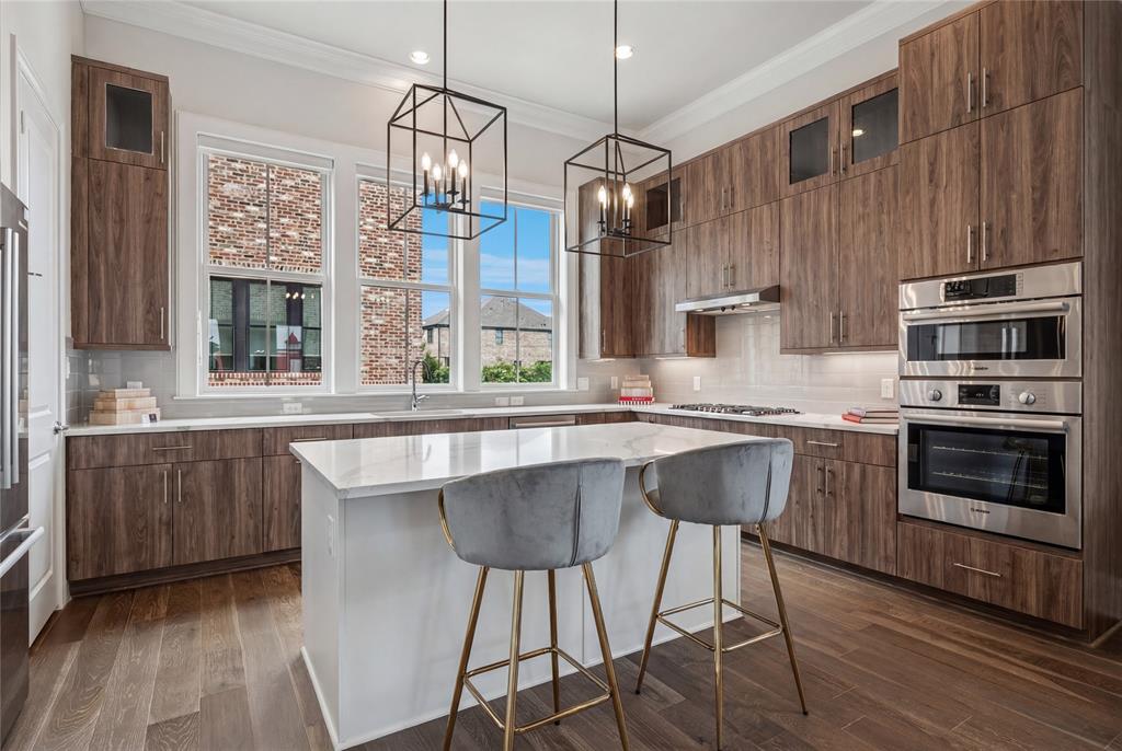 14953 Holly Street Addison, TX 75001 - Photo 5 of 17 a kitchen with stainless steel appliances a stove a sink island and a wooden cabinets