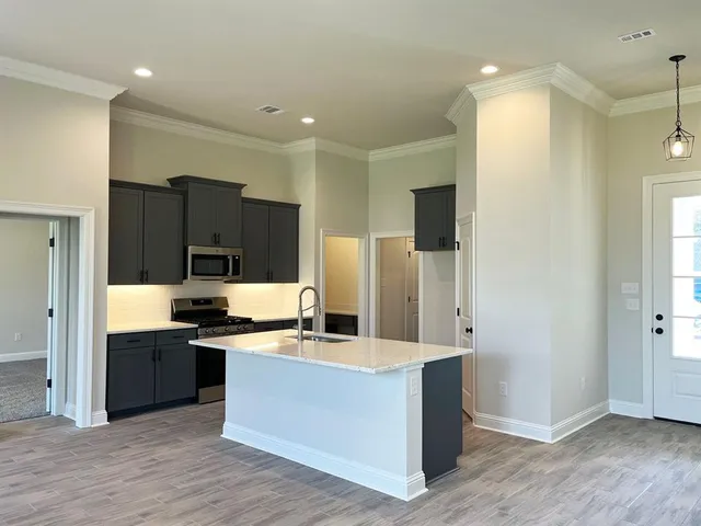 a kitchen with stainless steel appliances kitchen island granite countertop a refrigerator and a sink