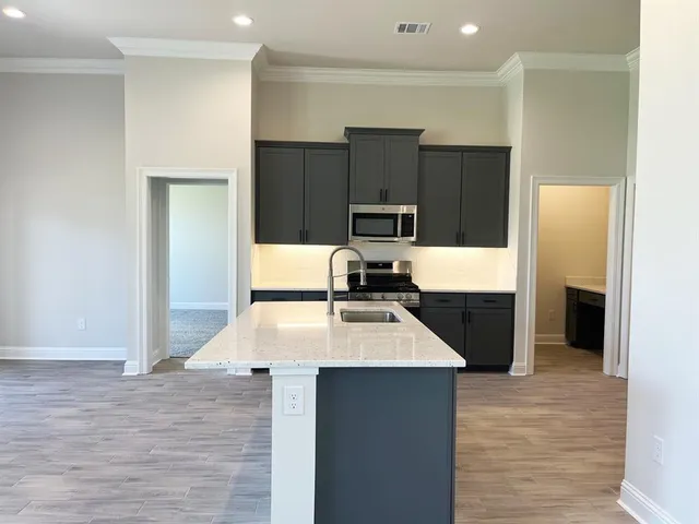 a kitchen with kitchen island granite countertop a refrigerator and a sink