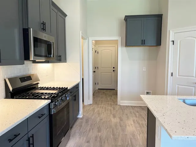 a kitchen with stainless steel appliances granite countertop a stove and a microwave