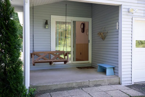 a view of a balcony with chairs and a potted plant