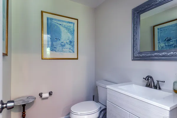 a bathroom with a toilet a sink and mirror