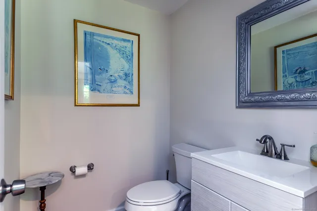 a bathroom with a toilet a sink and mirror