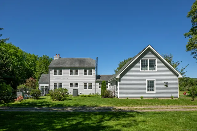 a view of a house with a big yard and potted plants