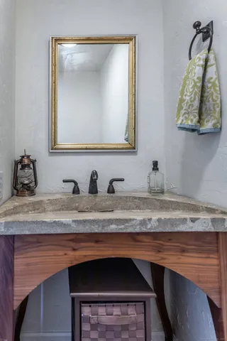 a bathroom with a granite countertop sink and a mirror