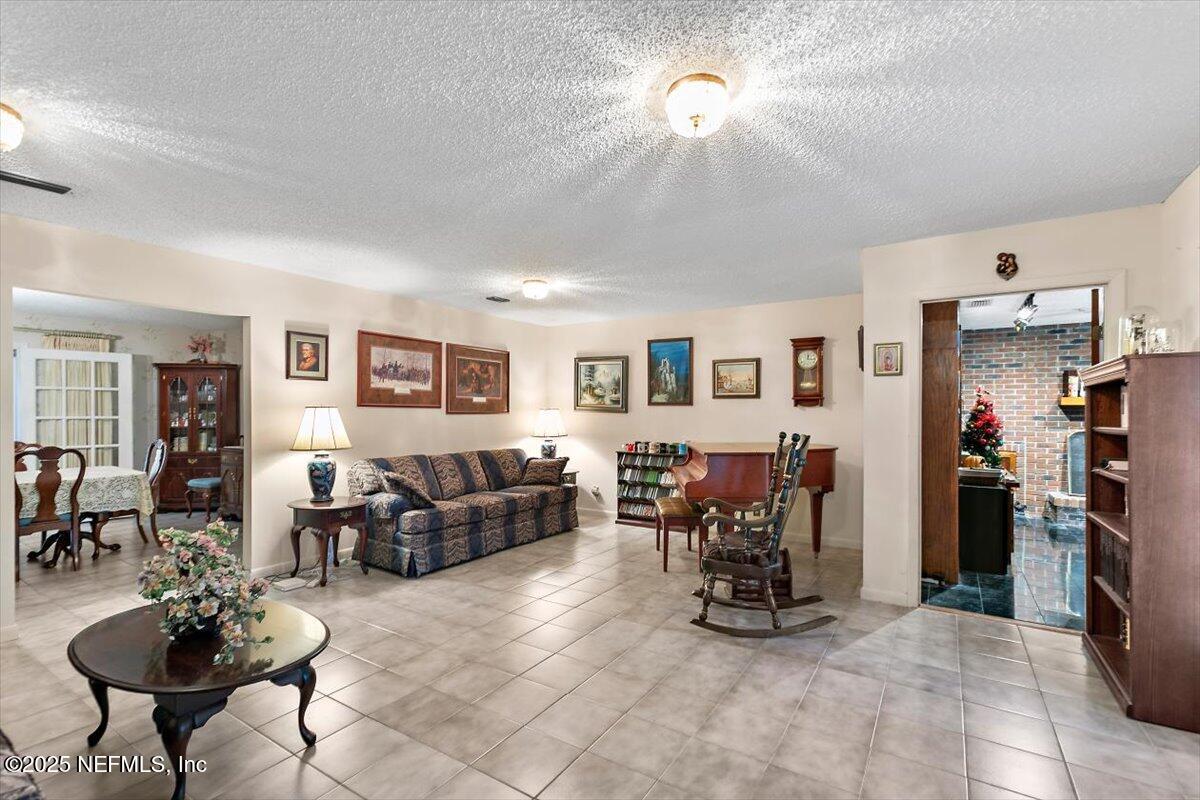 2634 Joe Ashton Road St. Augustine, FL 32092 - Photo 11 of 49 a living room with furniture and a dining table with kitchen view