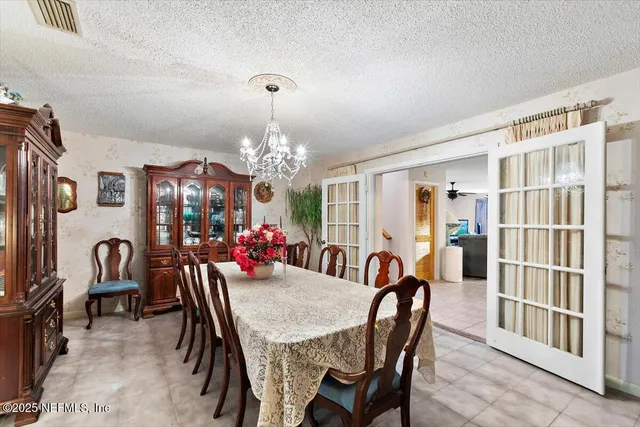 a view of a dining room with furniture a chandelier and window