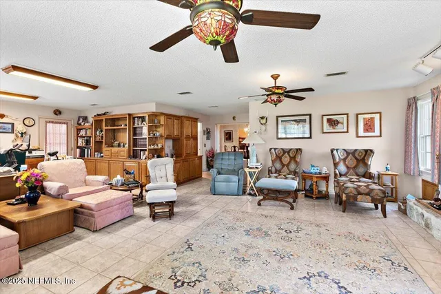 a living room with furniture gym equipment and a chandelier
