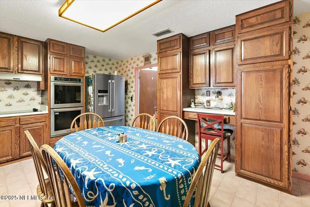 a view of a dining room with furniture a chandelier and wooden floor
