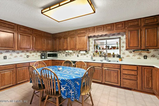 a kitchen with stainless steel appliances granite countertop a sink table and chairs