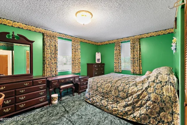 a bed room with a bed mirror and a window