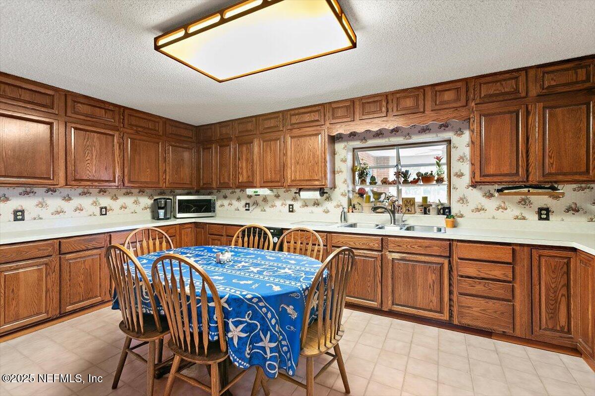 2634 Joe Ashton Road St. Augustine, FL 32092 - Photo 23 of 49 a kitchen with stainless steel appliances granite countertop a sink table and chairs