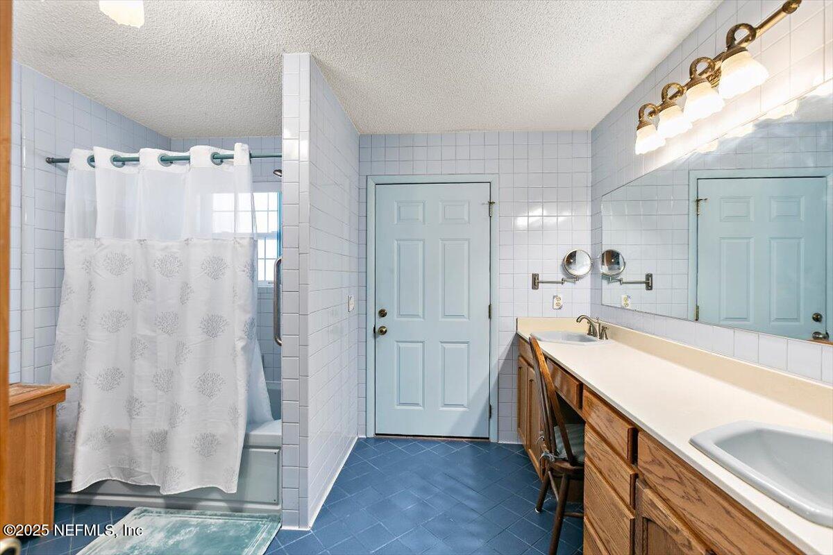 2634 Joe Ashton Road St. Augustine, FL 32092 - Photo 33 of 49 a bathroom with a sink a mirror and a shower