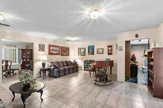 a living room with furniture and a dining table with kitchen view