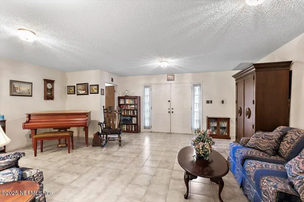 a living room with furniture and a dining table with kitchen view