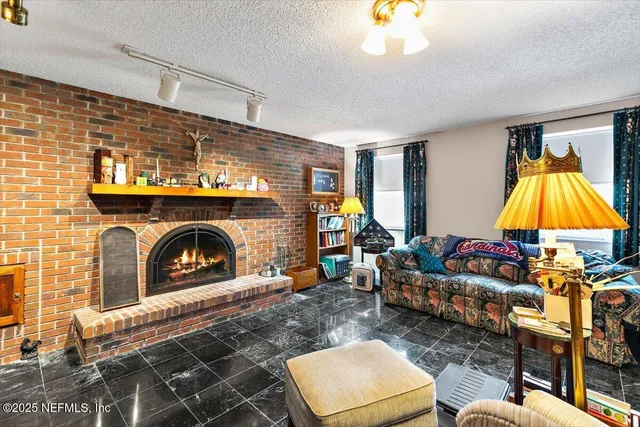 a living room with furniture a fireplace and a flat screen tv