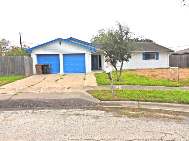 a view of a house with a yard and large tree
