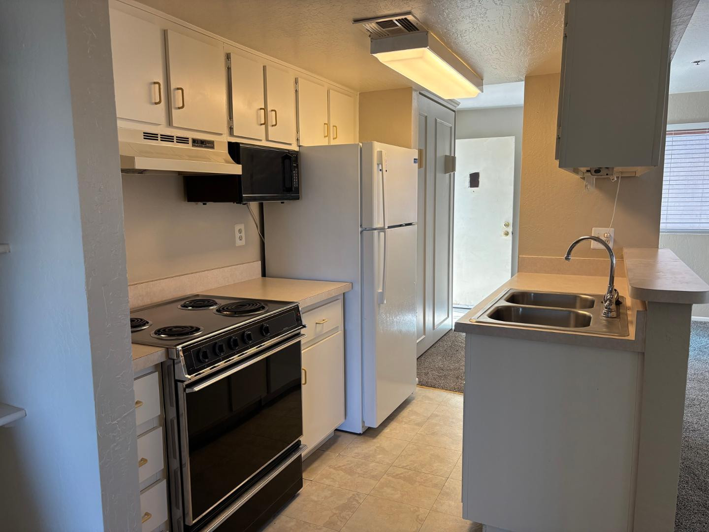 12123 West Bell Road, Unit 225 Surprise, AZ 85378 - Photo 4 of 12 a kitchen with stainless steel appliances granite countertop a stove and a refrigerator