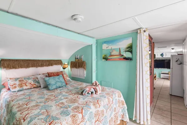 a bedroom with a large bed and a chandelier