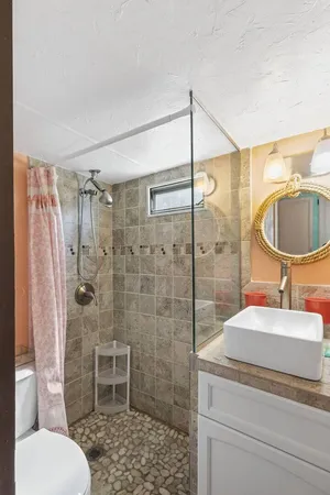 a bathroom with a sink toilet a mirror and shower