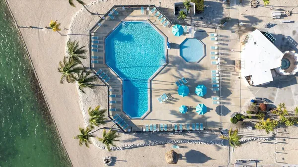 a view of a swimming pool with a patio and fire pit