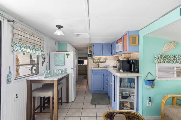 a kitchen with kitchen island stainless steel appliances a table chairs sink and cabinets