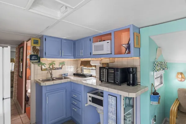a kitchen with kitchen island granite countertop a refrigerator stove top oven and sink