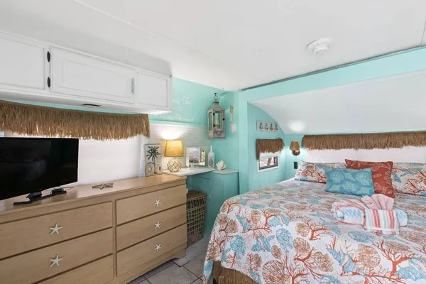 a bedroom with a bed and a flat tv screen in it