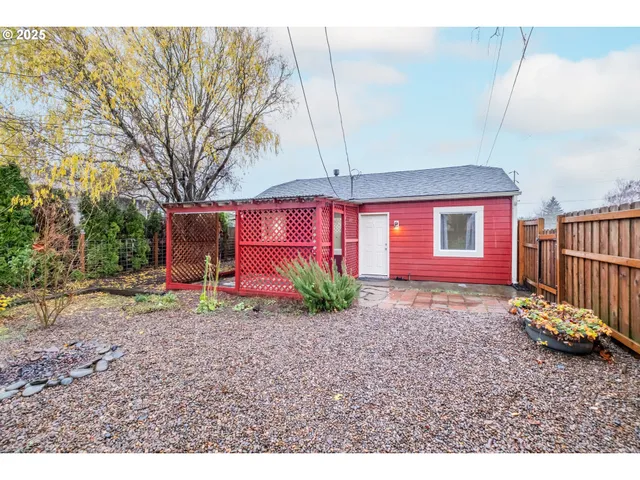 a backyard of a house with barbeque oven a table and chairs