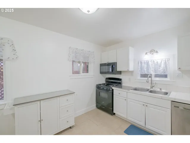 a kitchen with a sink cabinets and a window