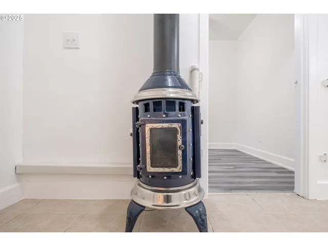 an empty room with wooden floor and fan