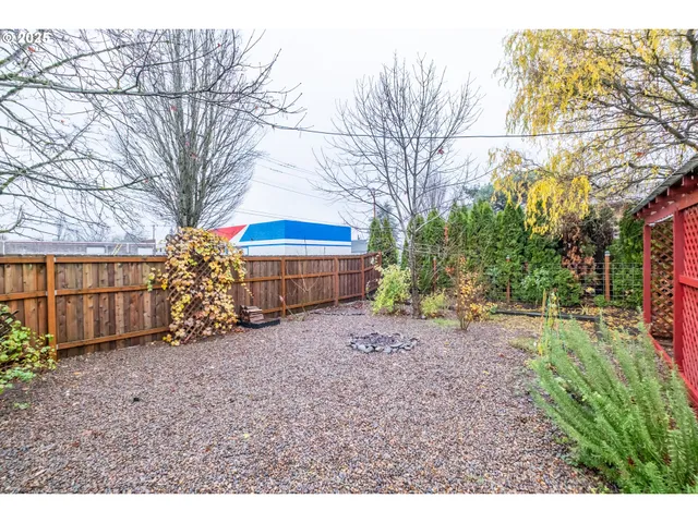a backyard of a house with barbeque oven table and chairs