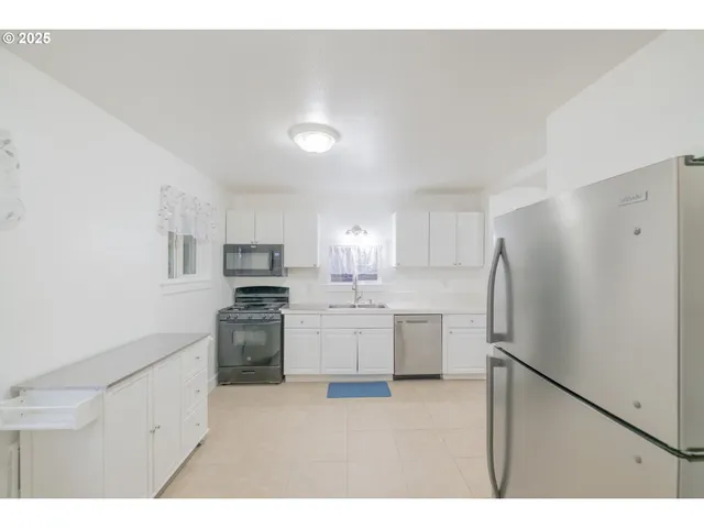 a kitchen with a refrigerator a stove top oven and cabinets