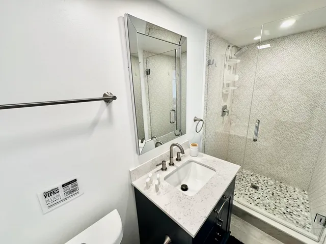a bathroom with a sink a toilet and mirror