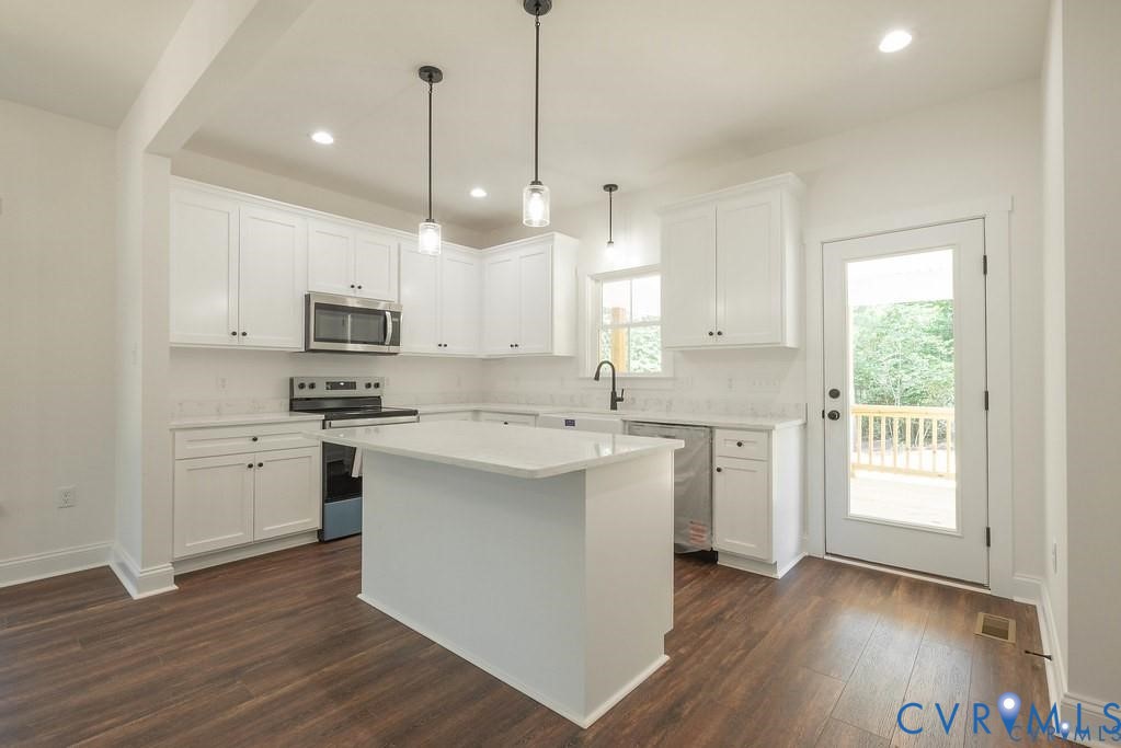 Lot 1 Robertson Town Road Bumpass, VA 23024 - Photo 20 of 40 a kitchen with kitchen island granite countertop a sink cabinets and wooden floor