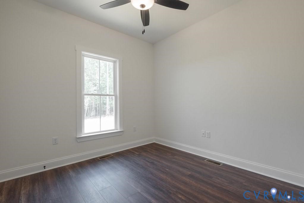 Lot 1 Robertson Town Road Bumpass, VA 23024 - Photo 33 of 40 an empty room with wooden floor chandelier fan and window