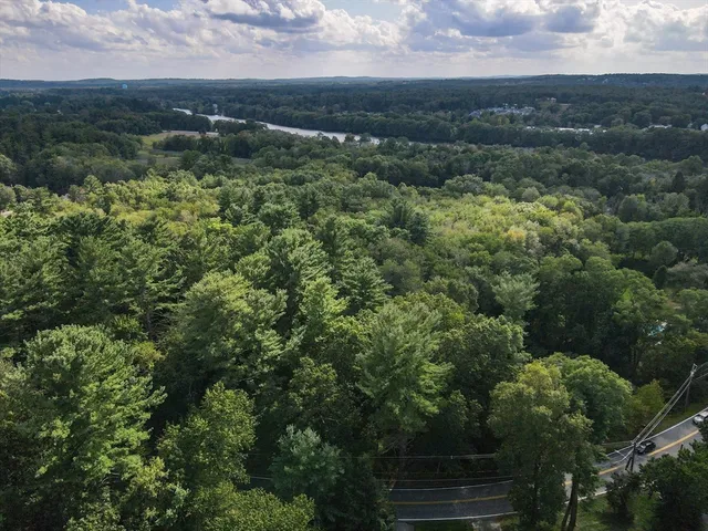 an aerial view of residential houses with outdoor space and trees