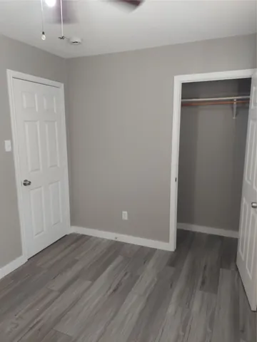 a room with wooden floor and windows