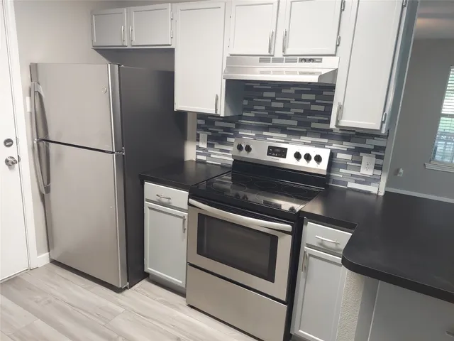 a kitchen with stainless steel appliances granite countertop a sink stove and cabinets