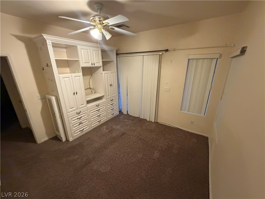 7629 Rory Court Las Vegas, NV 89129 - Photo 24 of 25 Built-in shelving and a ceiling fan enhance this cozy bedroom space.