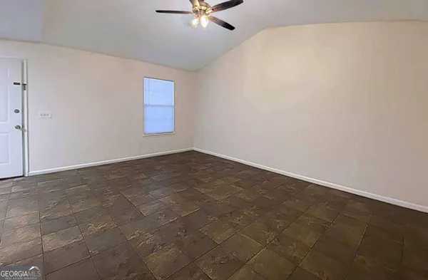 an empty room with a window and a ceiling fan