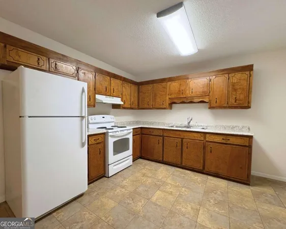 a kitchen with stainless steel appliances granite countertop a refrigerator sink and cabinets