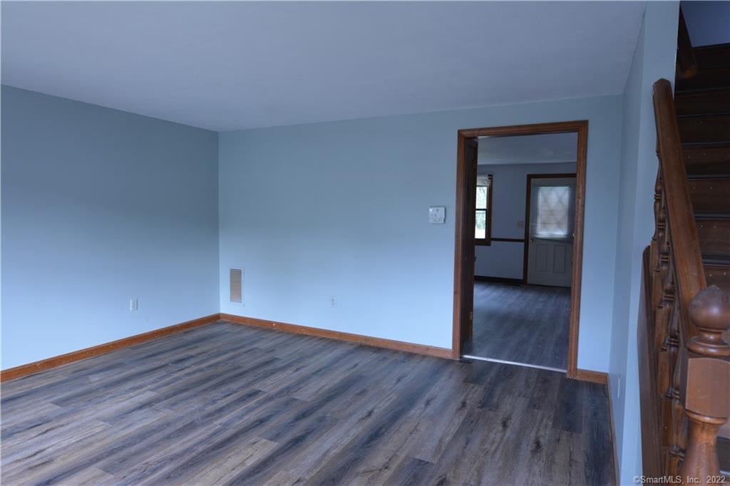 a view of a room with wooden floor and a hallway