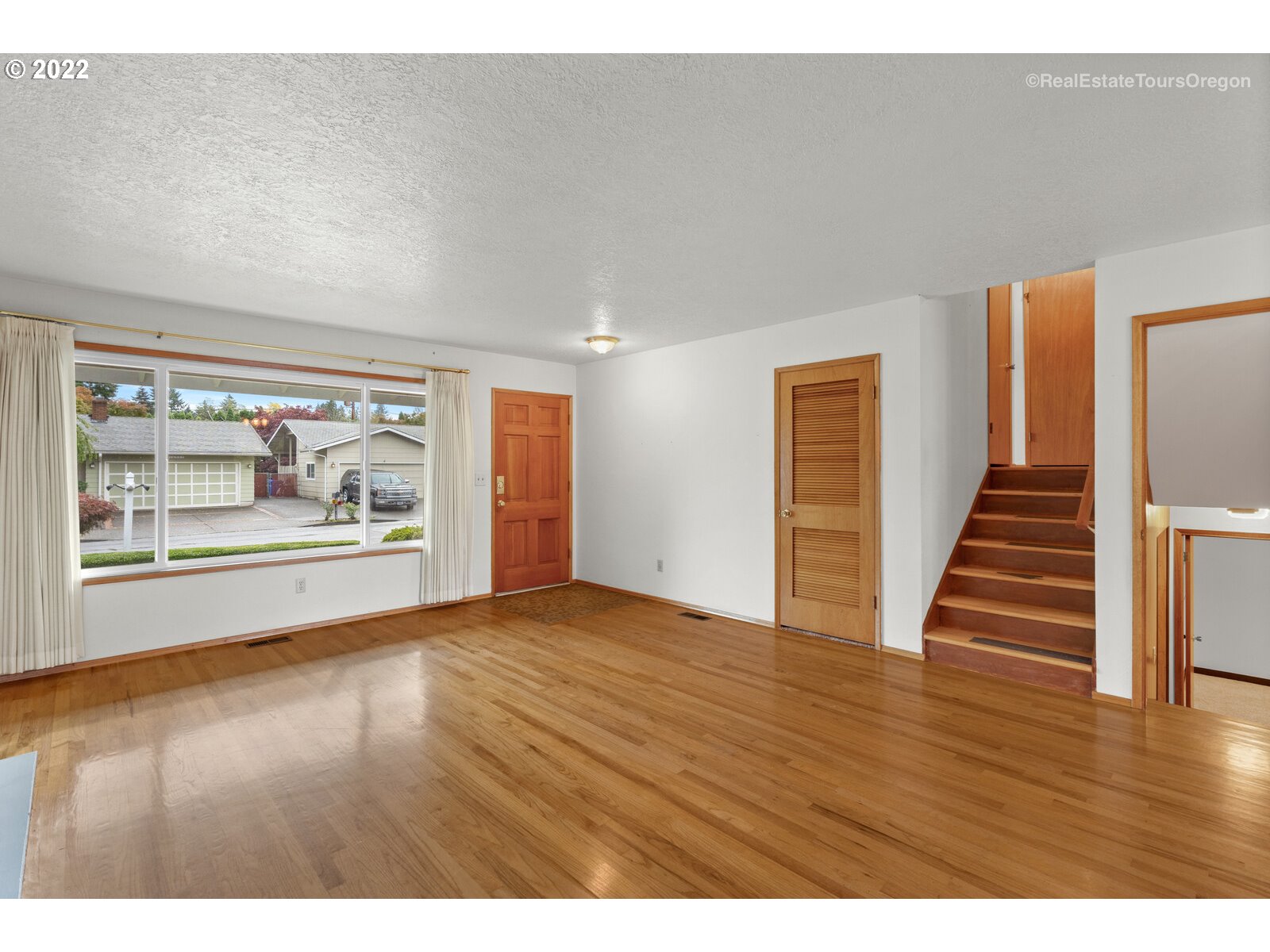 16901 Southeast Haig Street Portland, OR 97236 - Photo 4 of 32 a view of an empty room with wooden floor and a window
