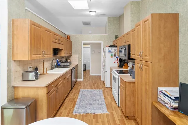 a kitchen with kitchen island granite countertop a sink appliances cabinets and a counter top space