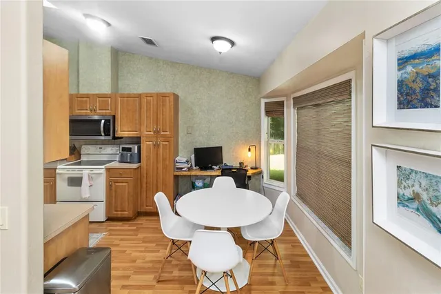 a kitchen with a refrigerator a stove a sink dishwasher with a dining table and chairs