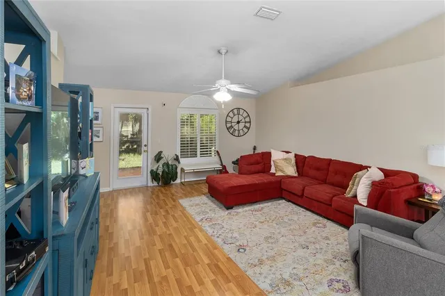 a living room with furniture a flat screen tv and a large window